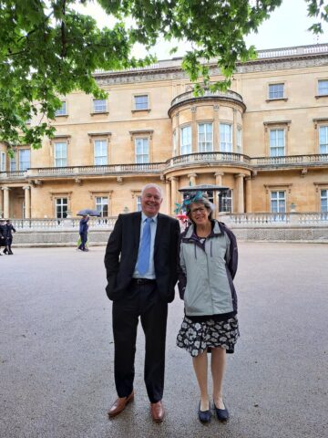 Westbank volunteers Maurice Lloyd and Ros Kukor brave the rain at Buckingham Palace, May 2022. Image: Maurice Lloyd.