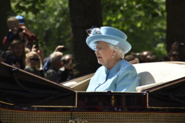 Queen Elizabeth II rides to the Trooping of the Colour, in 2018, in a horse drawn carriage wearing a pale blue outfit. Image: John Hitchins / Shutterstock.