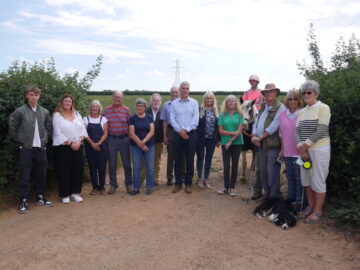 Image shows protestors at Marsh Green with Devon CPRE Director Penny Mills (in green).