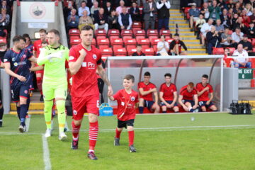 Adam Cummins, Stirling Albion captain, walking out onto the pitch with Tait Hiddleston. Image: Stirling Albion.