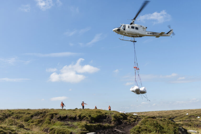 Airlifting bags of Brash for covering dried peat bogs as part of a peatland restoration project at Kinder Scout, Derbyshire. Image provided by The National Trust.