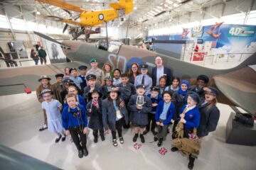 Children from Berrybrook Primary School children in front of world's oldest Spitfire celebrate a £13.7m funding from The National Lottery Heritage Fund for RAF and Royal Marine heritage. Photography: Chris Gorman (provided by The National Lottery Heritage Fund).